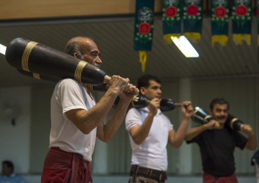 Men wielding wooden clubs during the traditional sport of zurkhaneh, Isfahan province, Kashan, Iran