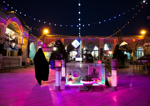 Iranian woman in chador going inside a mosque illuminated for Muharram to commemorate the martyrdom anniversary of Hussein, Isfahan Province, Isfahan, Iran
