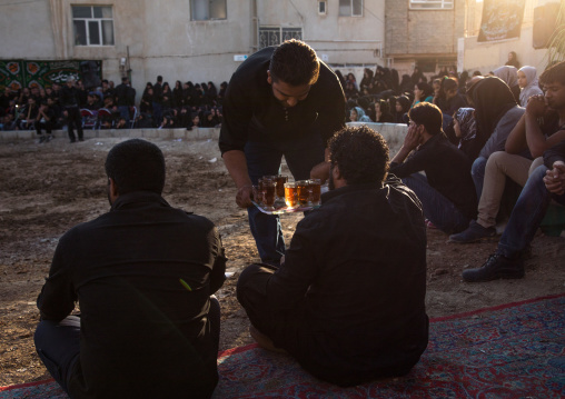 Iranian people drinking tea during a traditional religious theatre called tazieh about Imam Hussein death in Kerbala, Isfahan Province, Isfahan, Iran