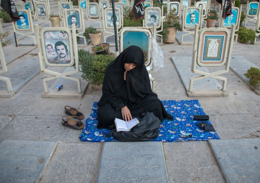 Portrait of an iranian shiite mother mourning in the rose garden of martyrs cemetery, Isfahan Province, Isfahan, Iran