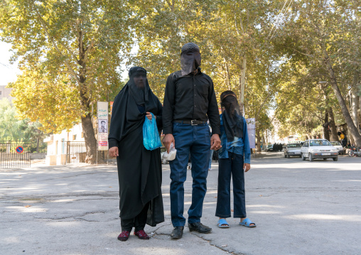 Iranian shiite muslim family mourning Imam Hussein on the day of Tasua with their faces covered by a veil, Lorestan Province, Khorramabad, Iran