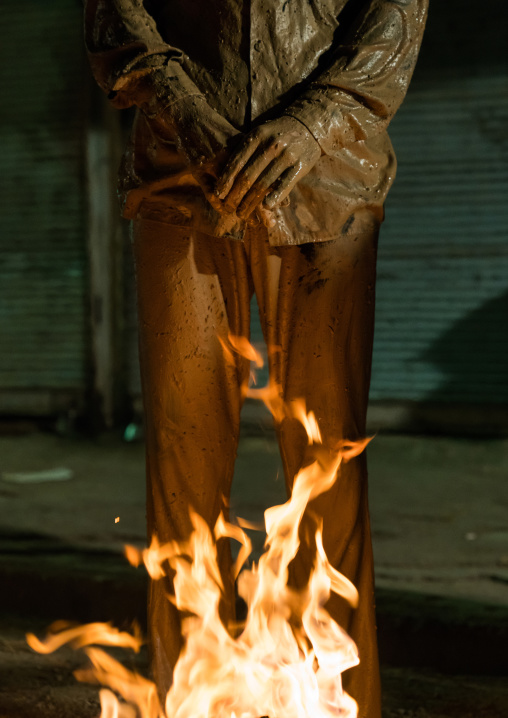 Iranian shiite muslim man standing in front of a bonfire after rubbing mud on his body during the Kharrah Mali ritual to mark the Ashura ceremony, Lorestan Province, Khorramabad, Iran