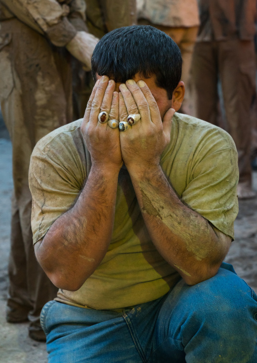 Iranian shiite muslim man crying after rubbing mud on his body during the Kharrah Mali ritual to mark the Ashura day, Lorestan Province, Khorramabad, Iran