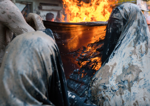 Iranian shiite muslim women gather around a bonfire after rubbing mud on their chadors during the Kharrah Mali ritual to mark the Ashura day, Lorestan Province, Khorramabad, Iran