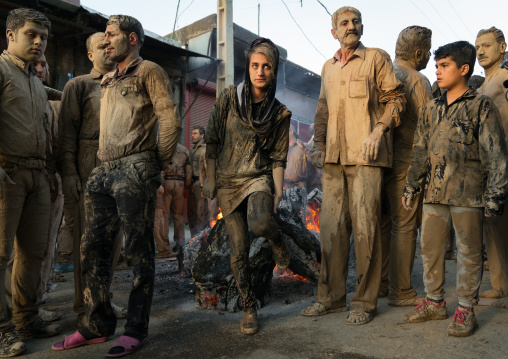 Iranian shiite muslim men gather around a bonfire after rubbing mud on their clothes during the Kharrah Mali ritual to mark the Ashura day, Lorestan Province, Khorramabad, Iran
