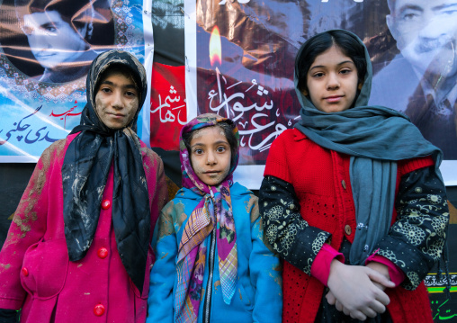 Iranian shiite muslim girls with mud stains watch the rubbing mud ritual during the Ashura day, Lorestan Province, Khorramabad, Iran