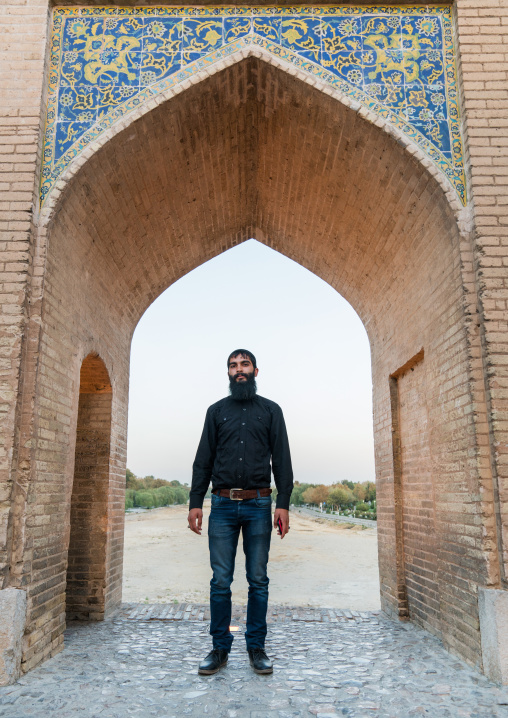 Man with a beard standing on Khaju bridge Pol-e Khaju over dry Zayandeh river, Isfahan Province, Isfahan, Iran