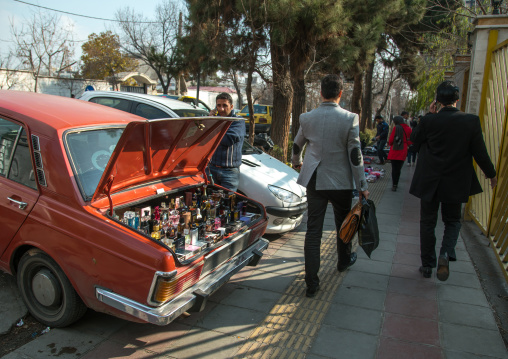 man selling perfumes bottles in the back of his car in the street, Central district, Tehran, Iran