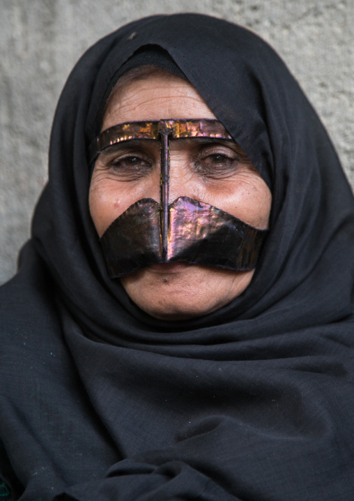 a bandari woman wearing a traditional mask called the burqa with a moustache shape, Qeshm Island, Salakh, Iran