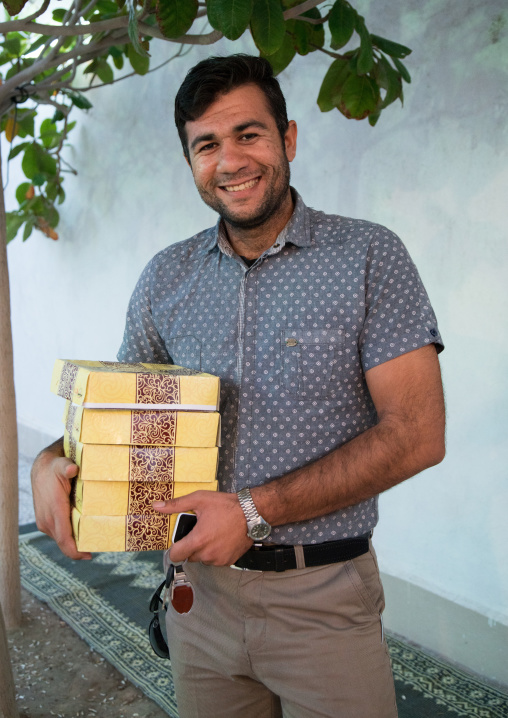 man carrying cakes offered during a wedding ceremony, Hormozgan, Bandar-e Kong, Iran
