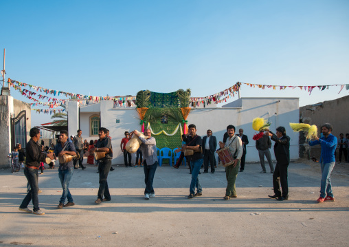 men dancing and playing music during a wedding ceremony, Hormozgan, Kushkenar, Iran