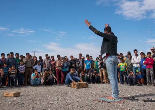 man walking on broken glass during a show on a market, Hormozgan, Minab, Iran