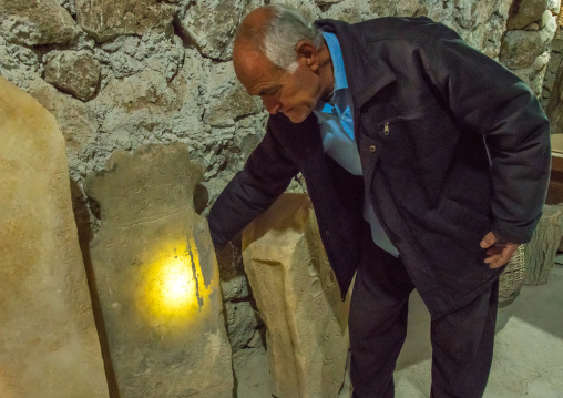 old man showing an albatre tombstone in his troglodyte house, Kerman province, Meymand, Iran