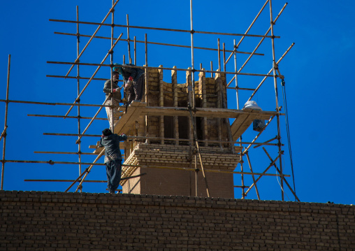 workers building of a wind tower in dolat abad garden, Central County, Yazd, Iran