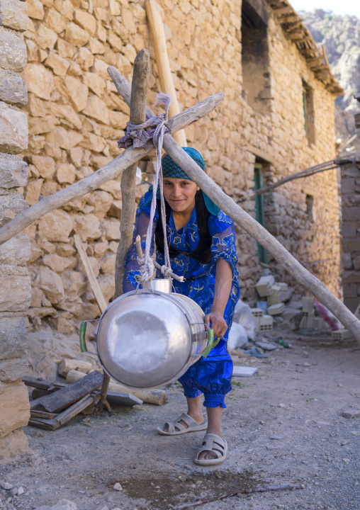 Woman Shaking Milk In The Old Kurdish Village Of Palangan At Dusk, Iran