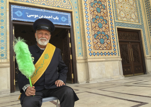 Guard with a green feather duster at the shah-e-cheragh mausoleum, Fars province, Shiraz, Iran