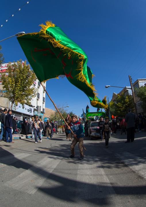 Iranian Shiite Muslim Boy Waving A Giant Green Flag During Ashura, The Day Of The Death Of Imam Hussein, Kurdistan Province, Bijar, Iran