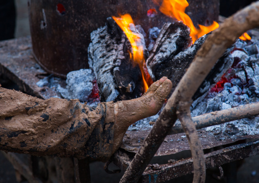 Iranian Shiite Muslim Man Covered In Mud Searching For Heat In Front Of A Fire During Ashura Day, Kurdistan Province, Bijar, Iran