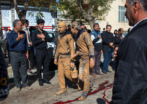 Iranian Shiite Muslim Men Covered In Mud With A Bucket During Ashura Day, Kurdistan Province, Bijar, Iran