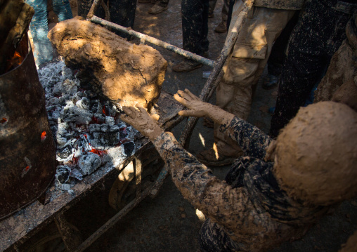 Iranian Shiite Muslim Boy Covered In Mud Searching For Heat In Front Of A Fire During Ashura Day, Kurdistan Province, Bijar, Iran