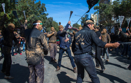 Iranian Shiite Men Covered In Mud Are Beating Themselves With Iron Chains During Ashura, The Day Of The Death Of Imam Hussein, Kurdistan Province, Bijar, Iran