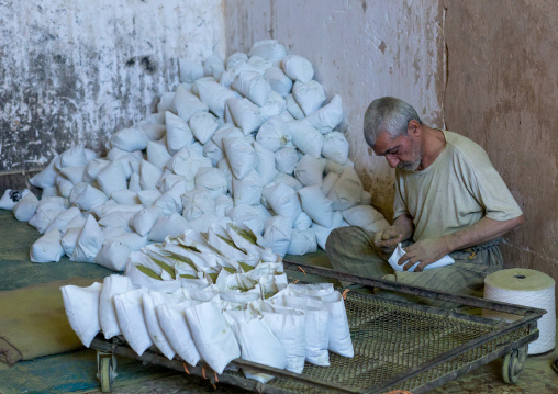 Iranian Worker Packing Henna Bags In A Traditional Mill, Yazd Province, Yazd, Iran