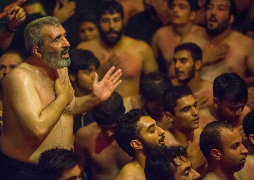 Iranian Shiite Muslim Man Leading Recitations And Songs With The Mad Of Hussein Mourners During Muharram, Isfahan Province, Kashan, Iran