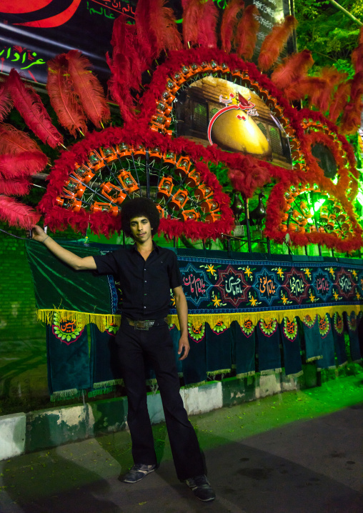 Young Iranian Shiite Muslim Man Mourner Pausing Proudly In Front Of An Alam On Ashura, The Day Of The Death Of Imam Hussein, Isfahan Province, Kashan, Iran