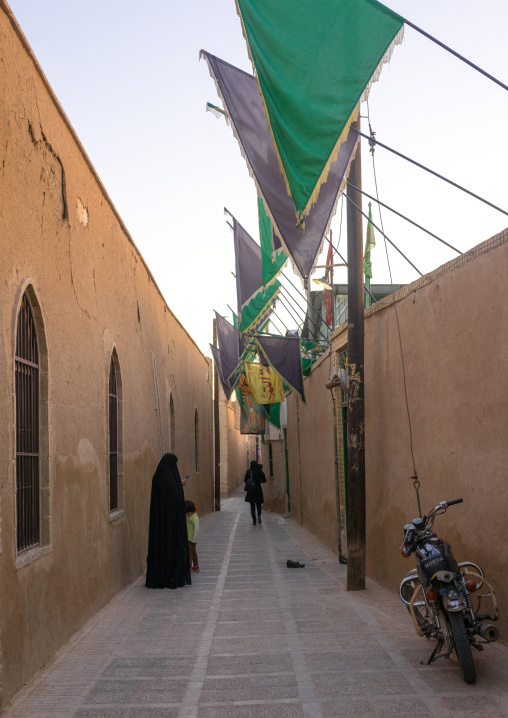 Muslim Women In A Narrow Street With Green Flags, Yazd Province, Yazd, Iran