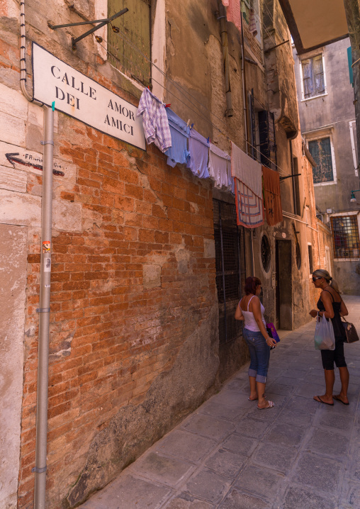 Italain women chatting in a narrow street of the old town, Veneto Region, Venice, Italy