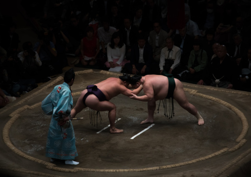 Two sumo wrestlers fighting at the ryogoku kokugikan arena, Kanto region, Tokyo, Japan