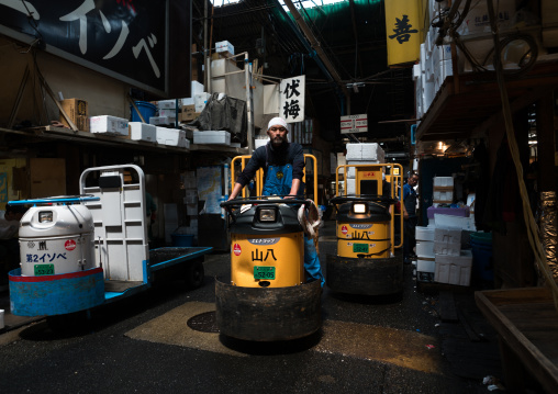 A man driving a motorized cargo cart called a taretto, Kanto region, Tokyo, Japan