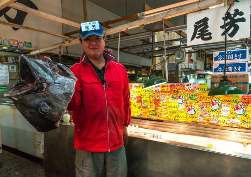 Vendor holding a big tuna fish in tsukiji fish market, Kanto region, Tokyo, Japan