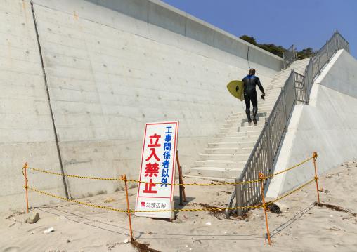 A authorized entry prohibited sign in front of a japanese surfer in the contaminated area after the daiichi nuclear power plant irradiation, Fukushima prefecture, Tairatoyoma beach, Japan