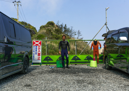 Japanese surfer in the contaminated area in front of a authorized entry prohibited sign
, Fukushima prefecture, Tairatoyoma beach, Japan