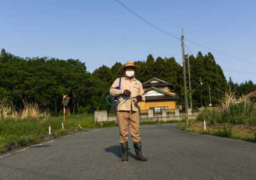 Man coming back in the contaminated area after the nuclear disaster to take care of his house and garden, Fukushima prefecture, Naraha, Japan