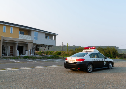 A fukushima police car in front of a house destroyed by the 2011 earthquake and tsunami five years after, Fukushima prefecture, Tomioka, Japan