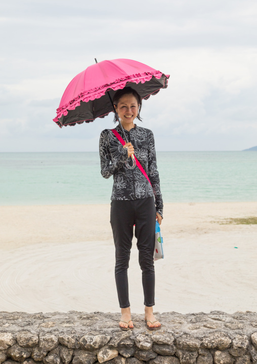 Japanese woman with an umbrella in kondoi beach, Yaeyama Islands, Taketomi island, Japan