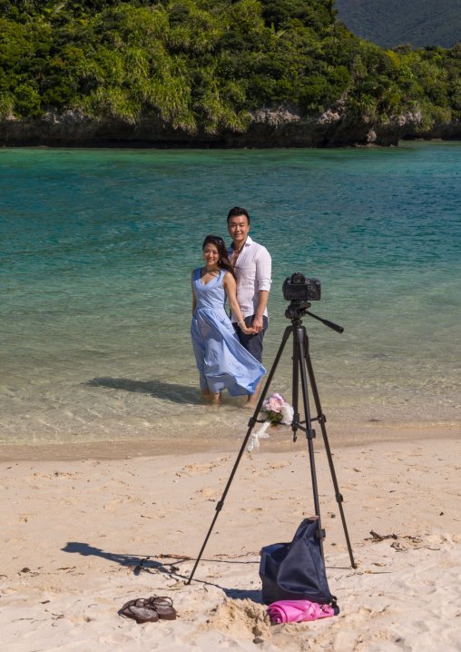Japanese couple posing in the tropical lagoon with clear blue water in Kabira bay, Yaeyama Islands, Ishigaki, Japan