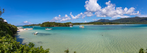 Glass bottom boats in the tropical lagoon beach with clear blue water and white sand in Kabira bay, Yaeyama Islands, Ishigaki, Japan