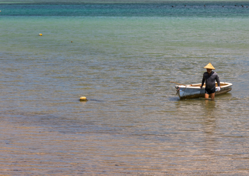 Japanese fisherman in tropical lagoon with clear blue water in Kabira bay, Yaeyama Islands, Ishigaki, Japan