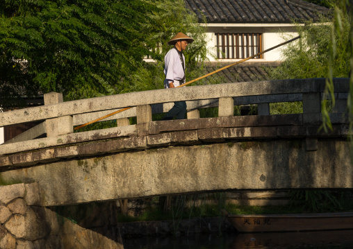 Japanese man in traditional clothing crossing a bridge, Okayama Prefecture, Kurashiki, Japan