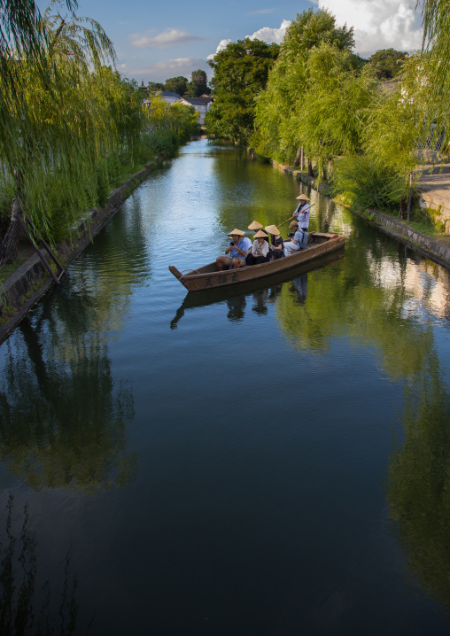 Tourists enjoying a cruise on a small boat on the river in Bikan historical quarter, Okayama Prefecture, Kurashiki, Japan
