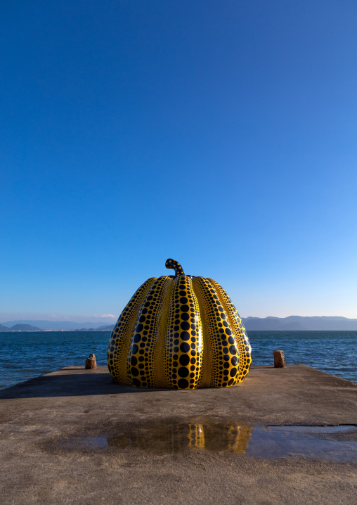 Yellow pumpkin by Yayoi Kusama on pier at sea, Seto Inland Sea, Naoshima, Japan
