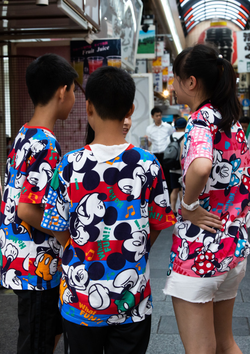 Teenagers in the street wearing Mickey mouse shirts, Kansai region, Osaka, Japan