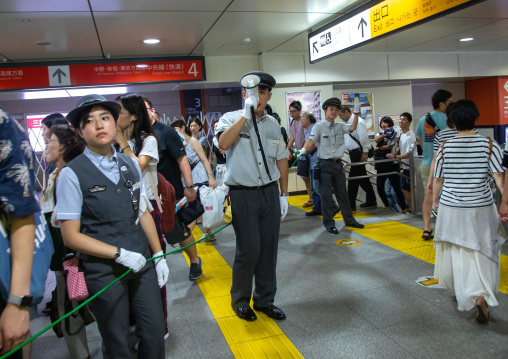 Policeman with megaphone in the subway, Kanto region, Tokyo, Japan