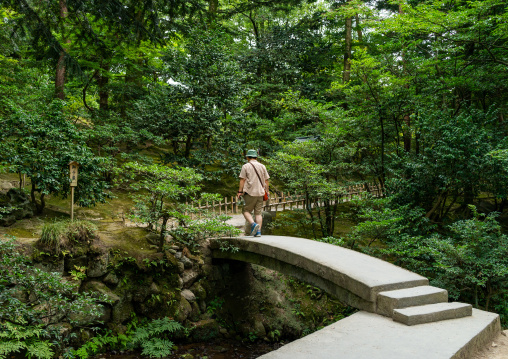 Man on a bridge in Kenroku-en garden, Ishikawa Prefecture, Kanazawa, Japan