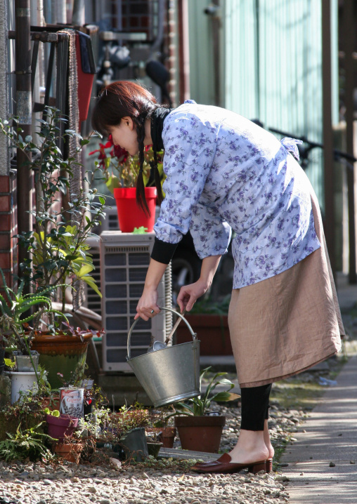 Japanese woman watering her plants, Kanto region, Tokyo, Japan