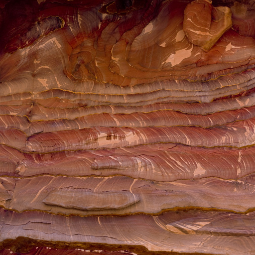 Waves Of Natural Color Drift Through A Sandstone Rock Face In Petra, Jordan