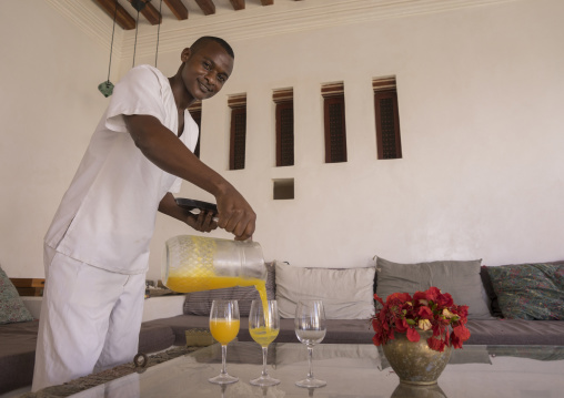 Waiter serving fruit juice in forodhani house, Lamu county, Shela, Kenya